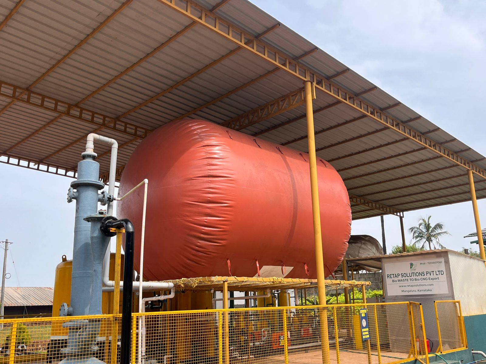 Industrial digester storage tanks against a clear sky